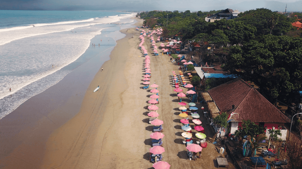 Aerial view of Seminyak Beach with colorful umbrellas.