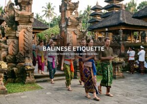 Tourists wearing traditional sarongs while visiting a Balinese temple and respecting local customs in Bali