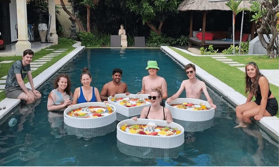 Group of friends gathered by the private pool at a Villa Bugis villa in Seminyak