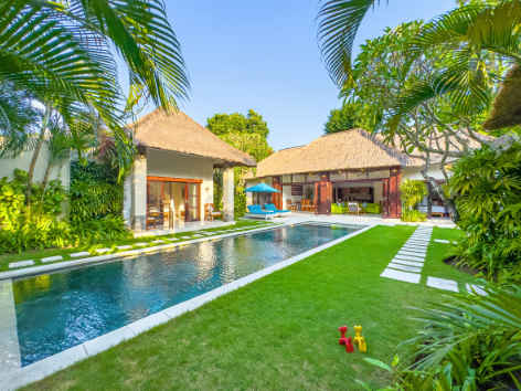 Private swimming pool with sun loungers and tropical garden at a Villa Bugis villa