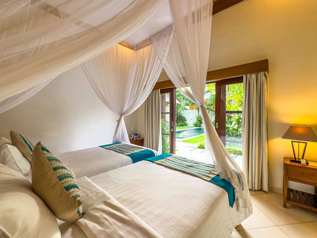 Airy twin bedroom 4 opening onto tropical garden views at Villa Alore Seminyak by Villa Bugis villa Seminyak, with air conditioning and tropical decor.
