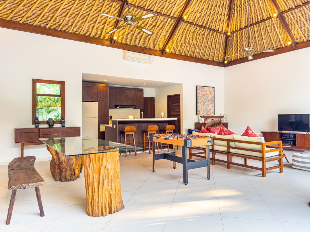 Open-air living room pavilion with plush sofa seating facing the pool at Villa Alore Seminyak by Villa Bugis villa Seminyak.