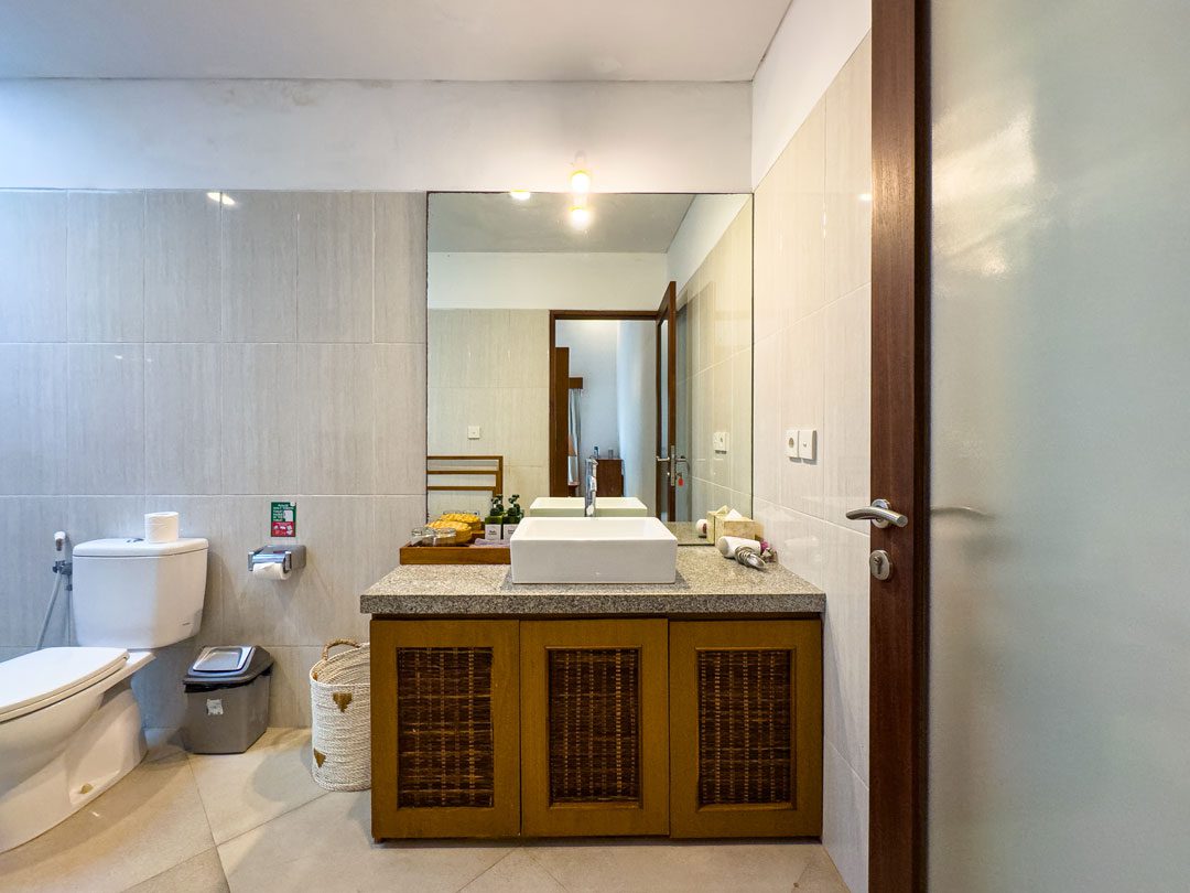 Clean stone vanity and refreshing shower area inside bathroom 2 at Villa Alore Seminyak by Villa Bugis villa Seminyak.