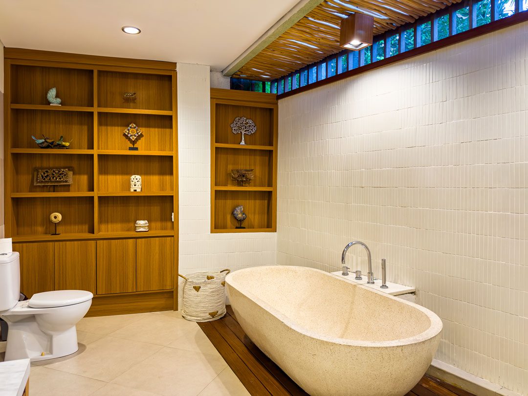 Ensuite luxury bathroom with a soaking bathtub for bedroom 6 at Villa Alore Seminyak by Villa Bugis, designed with modern Balinese elements.