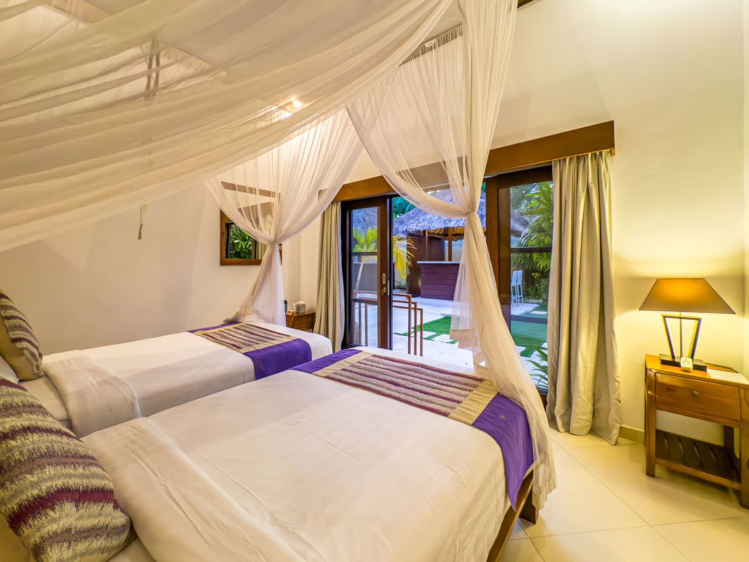 Twin bed setup with tropical garden views in bedroom 3 at Villa Alore Seminyak by Villa Bugis Seminyak villas, perfect for children or friends.