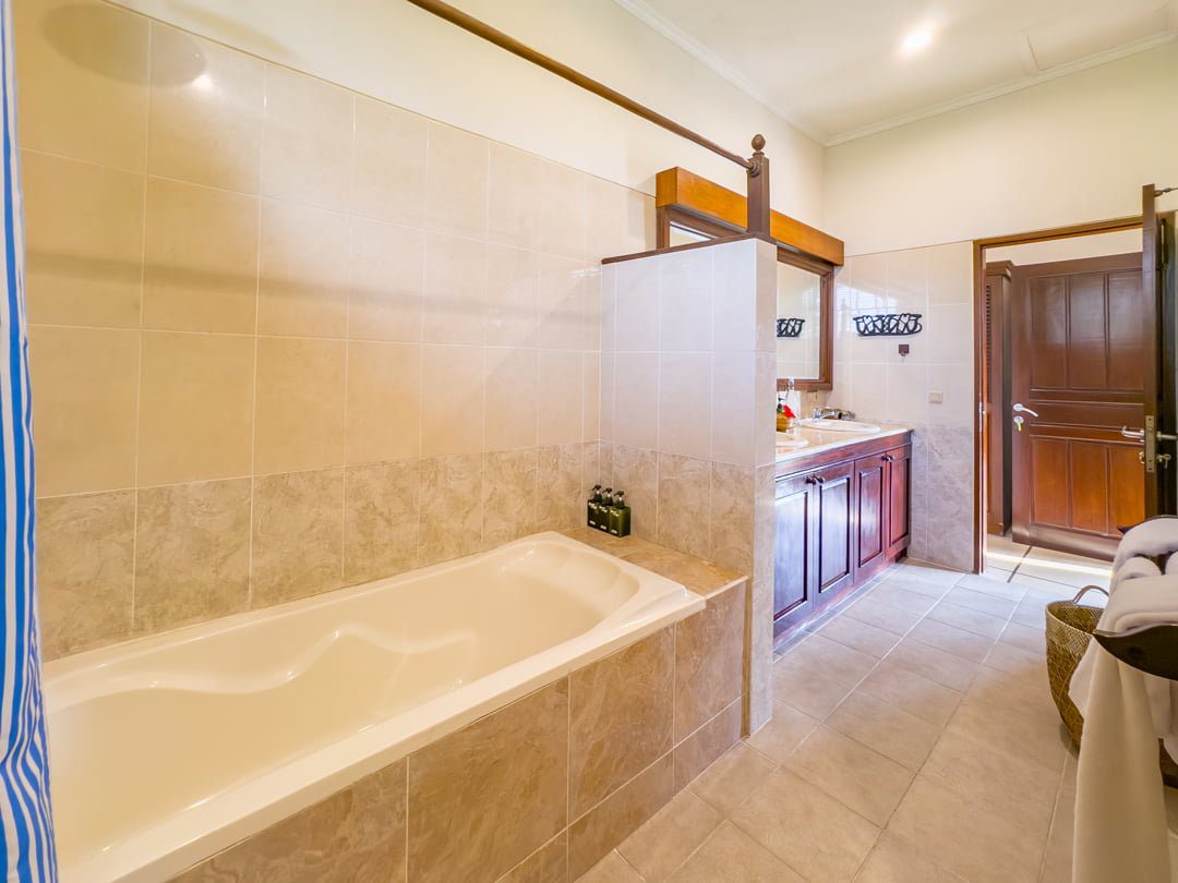 Clean modern vanity, stylish mirror, and premium amenities inside the master bathroom at Villa Arjuna Seminyak by Villa Bugis Seminyak villas.