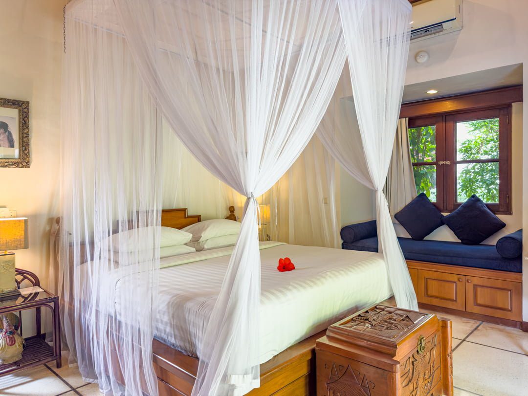Large comfortable bed with soft natural lighting in bedroom 2 at Villa Arjuna Seminyak by Villa Bugis, a highly recommended Seminyak villas choice.