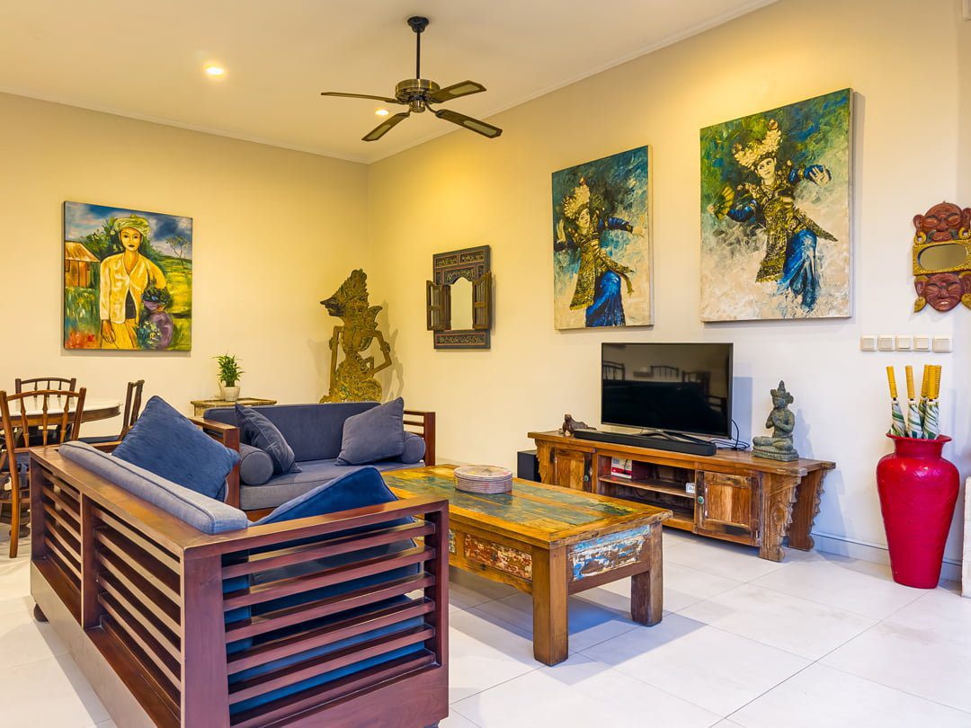 Elegant wooden furnishings and ambient lighting setup in the living room at Villa Arjuna Seminyak by Villa Bugis villa Seminyak.