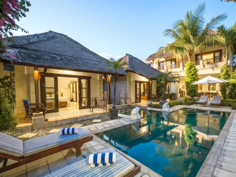 Villa Bugis private pool villa lit at night with warm garden lighting in Seminyak Bali