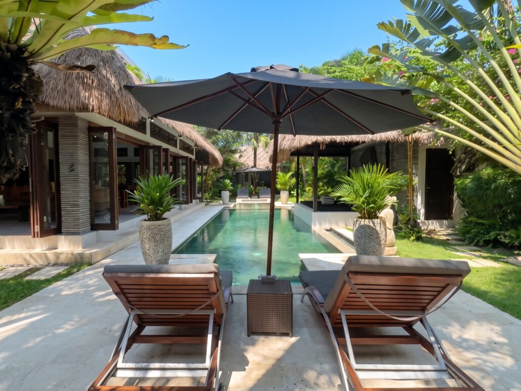 Serene private swimming pool surrounded by lush tropical gardens at Villa Damai Seminyak