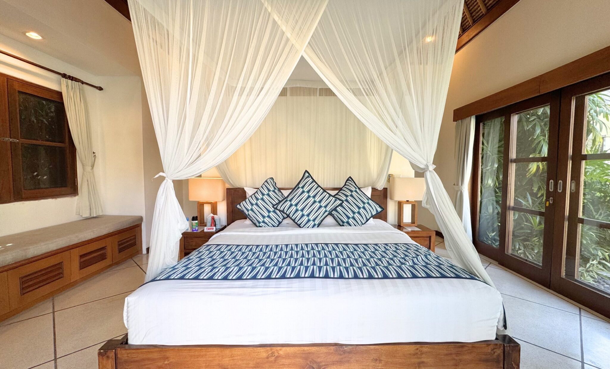 Elegant master bedroom with a king-size wooden bed frame at Villa Darma Seminyak by Villa Bugis, a top-rated villa Seminyak for a relaxing holiday.
