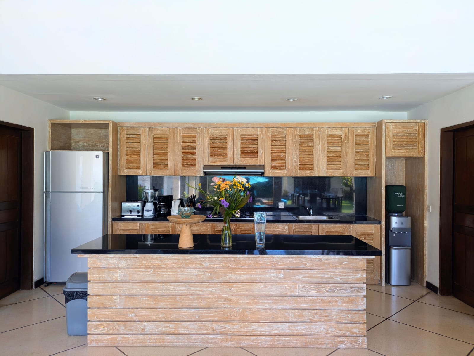 Modern open-plan kitchen fully equipped with high-quality cooking appliances at Villa Darma Seminyak by Villa Bugis villa Seminyak.