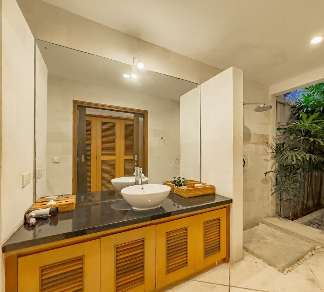 Well-lit vanity mirror and clean facilities inside the open-air bathroom of bedroom 4 at Villa Darma Seminyak by Villa Bugis Seminyak villas.