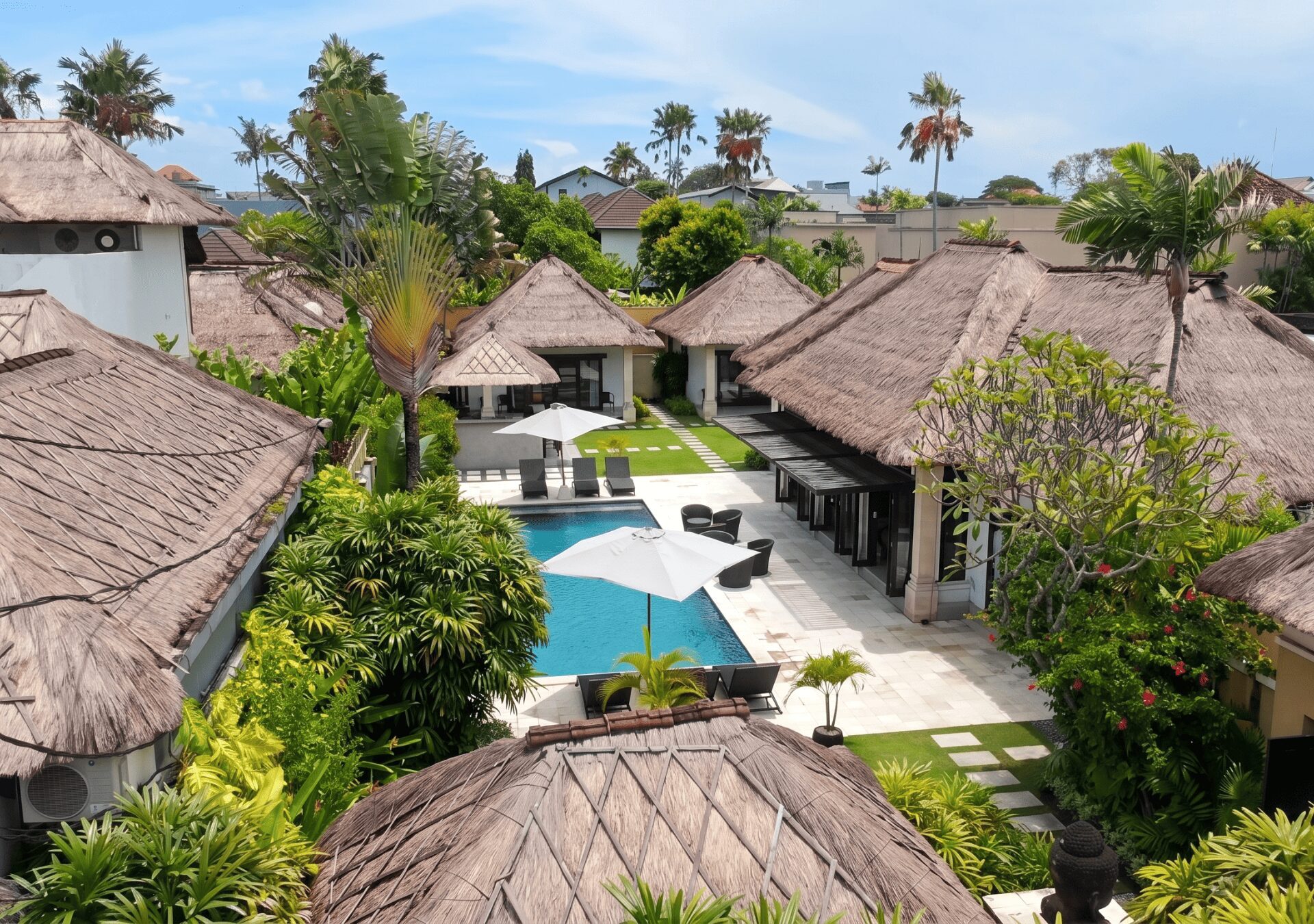 High-angle aerial drone view showing the full layout of the private swimming pool and lush tropical garden at Villa Gembira Seminyak by Villa Bugis villa Seminyak.