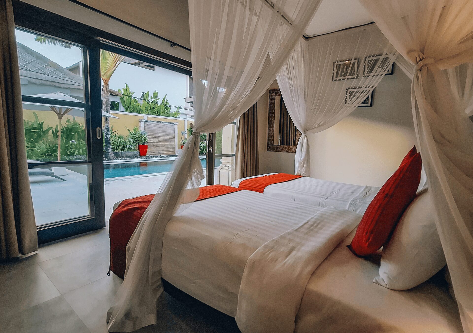 Airy guest room setup with pool views in bedroom 4 at Villa Gembira Seminyak by Villa Bugis Seminyak villas, equipped with air conditioning and tropical accents.