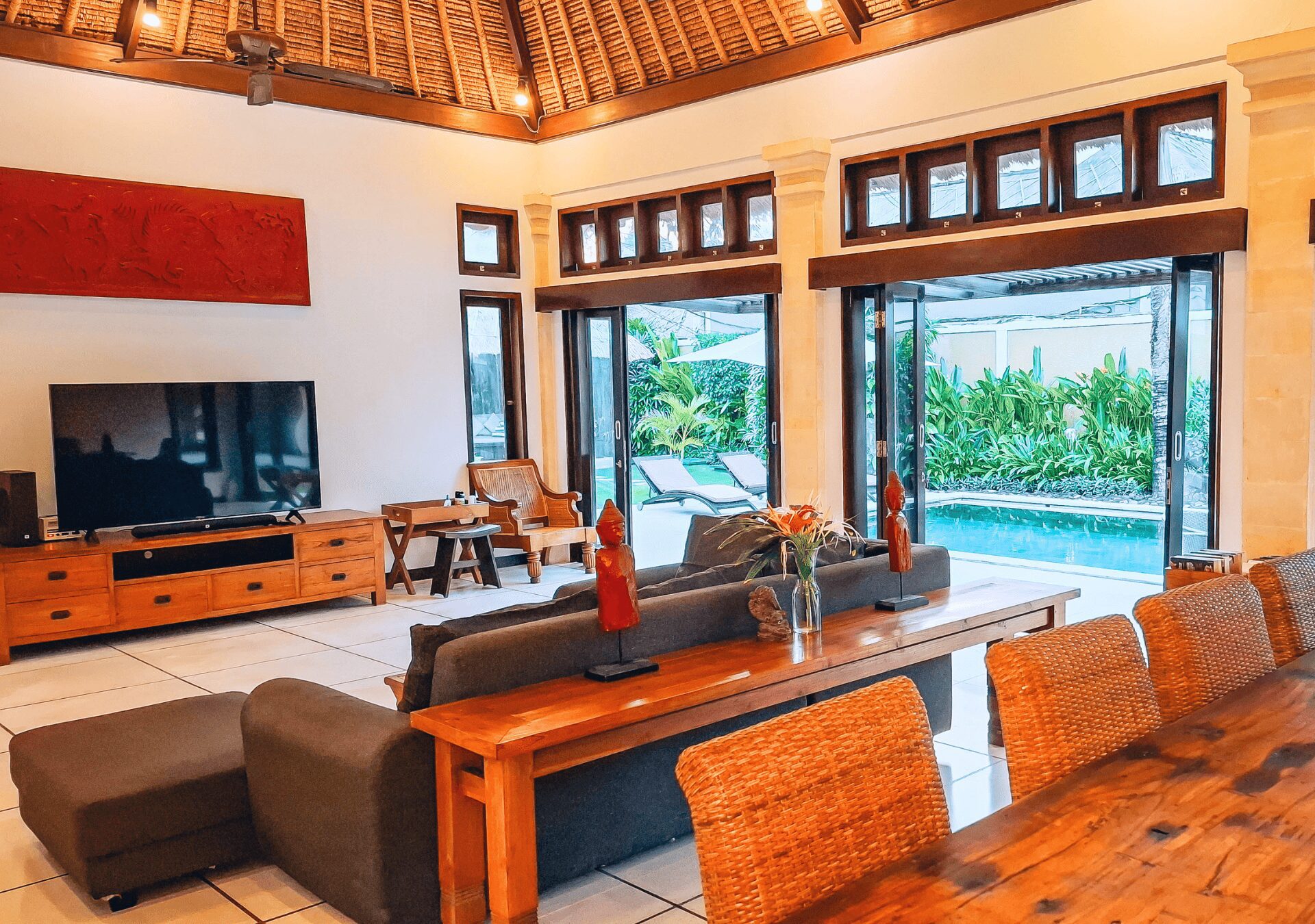Open-air living room pavilion with plush sofa seating facing the pool at Villa Gembira Seminyak by Villa Bugis villa Seminyak.