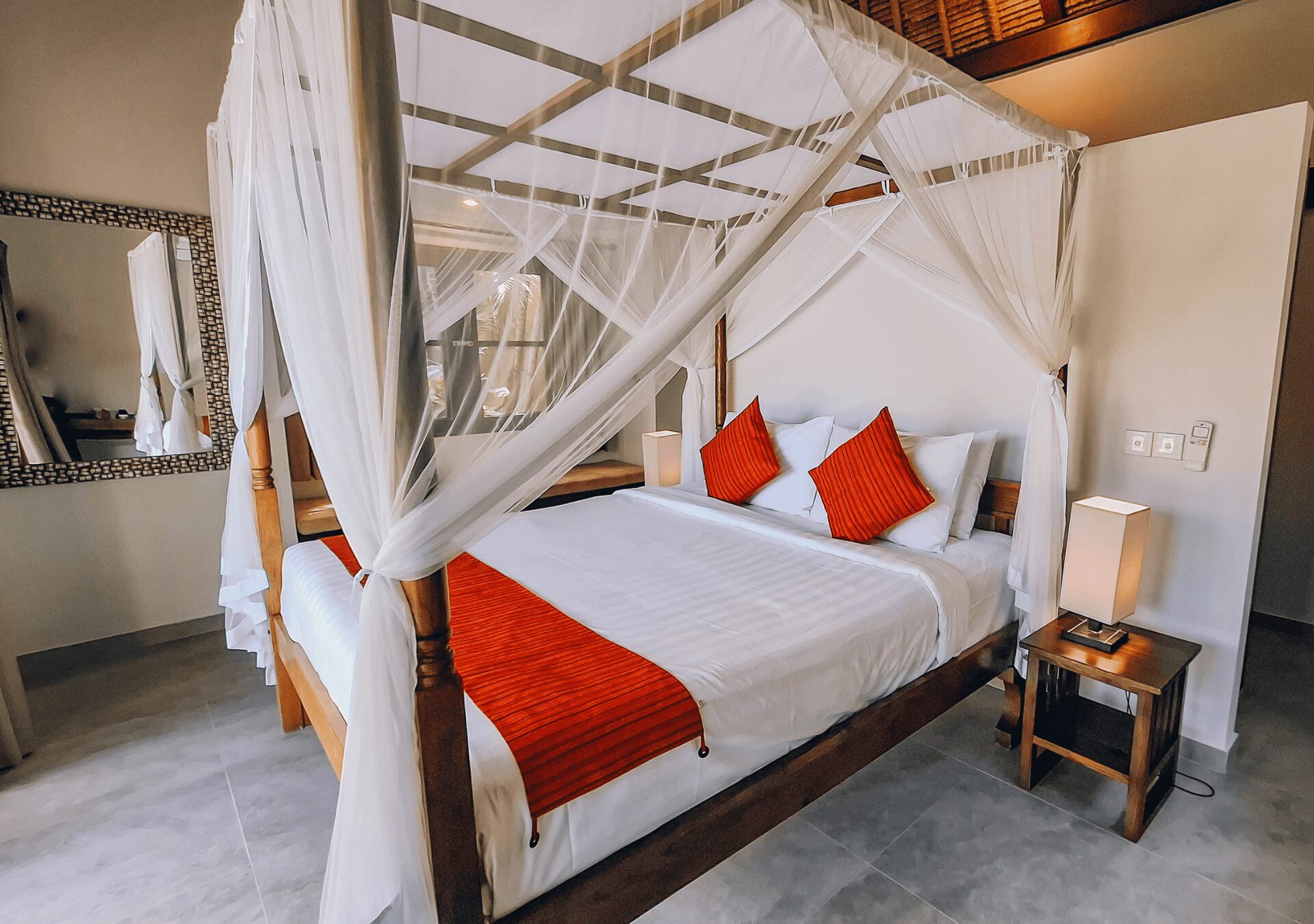 Spacious interior layout of bedroom 1 at Villa Gembira Seminyak by Villa Bugis Seminyak villas, complete with air conditioning and elegant wooden furnishings.