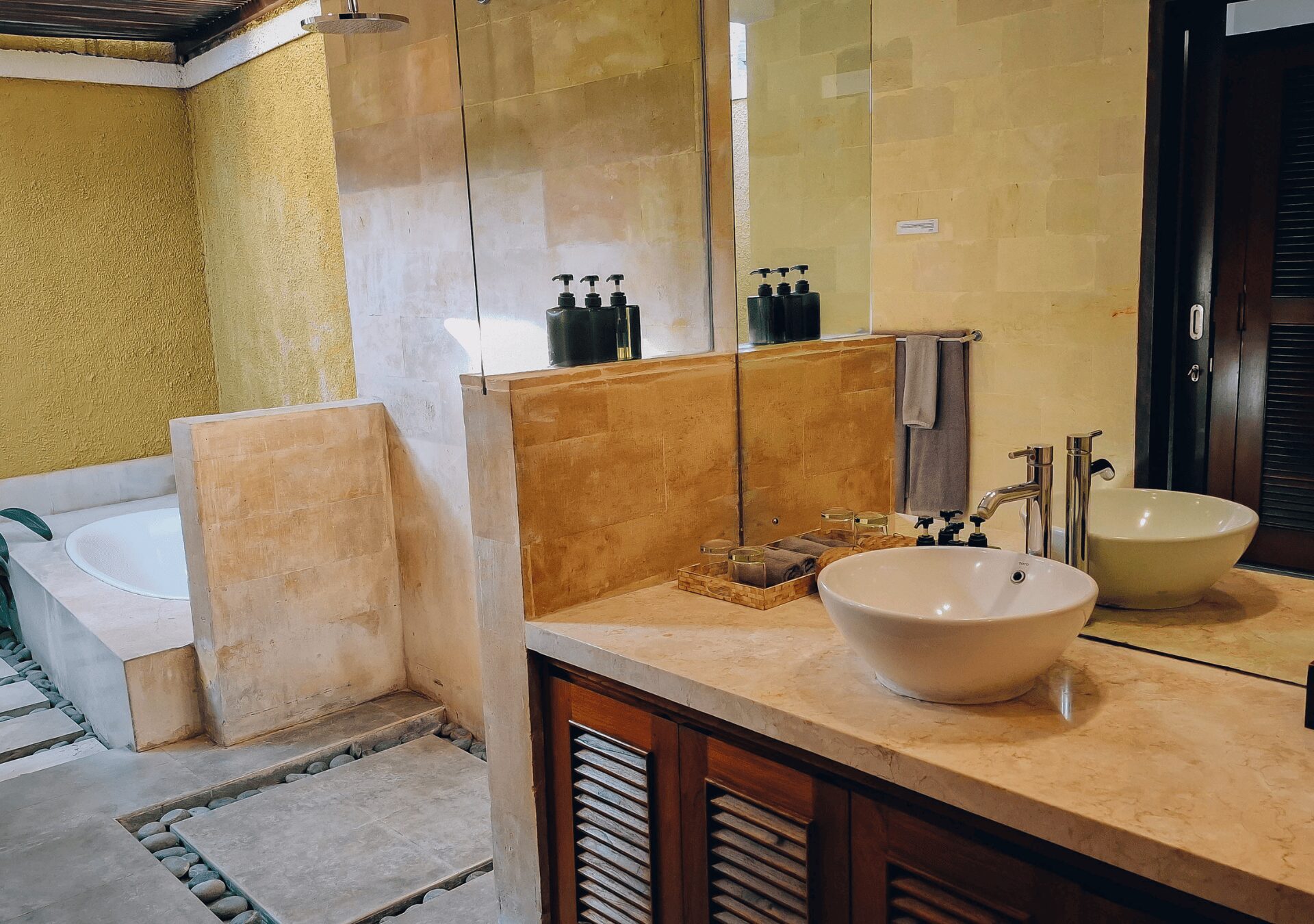 Clean modern vanity, stone basin, and refreshing shower area in the master bathroom at Villa Gembira Seminyak by Villa Bugis Seminyak villas.