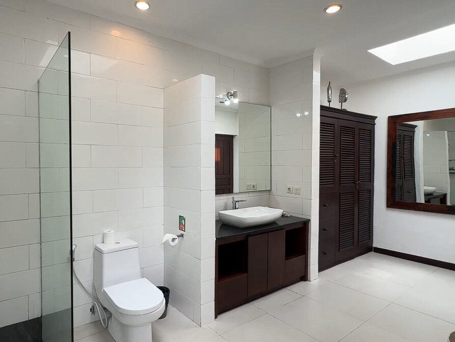 Modern stone vanity and clean amenities inside the private ensuite bathroom of bedroom 2 at Villa Ginger Seminyak by Villa Bugis villa Seminyak.