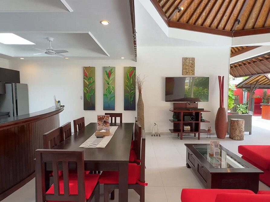 Elegant wooden furnishings and ambient lighting setup in the living and dining area at Villa Ginger Seminyak by Villa Bugis villa Seminyak.
