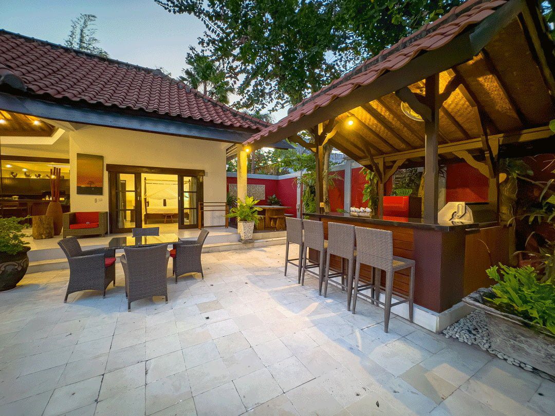 Warm night lighting highlighting the poolside bar and relaxation area at Villa Ginger Seminyak by Villa Bugis villa Seminyak.