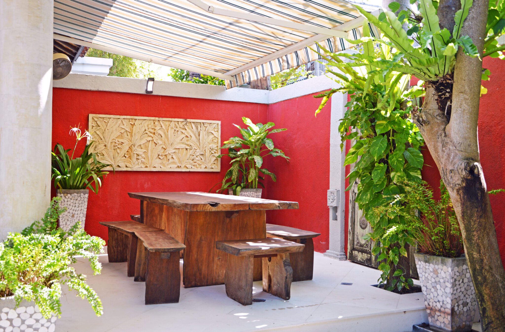 Tropical indoor-outdoor living concept with an outdoor dining table at Villa Ginger Seminyak by Villa Bugis Seminyak villas.