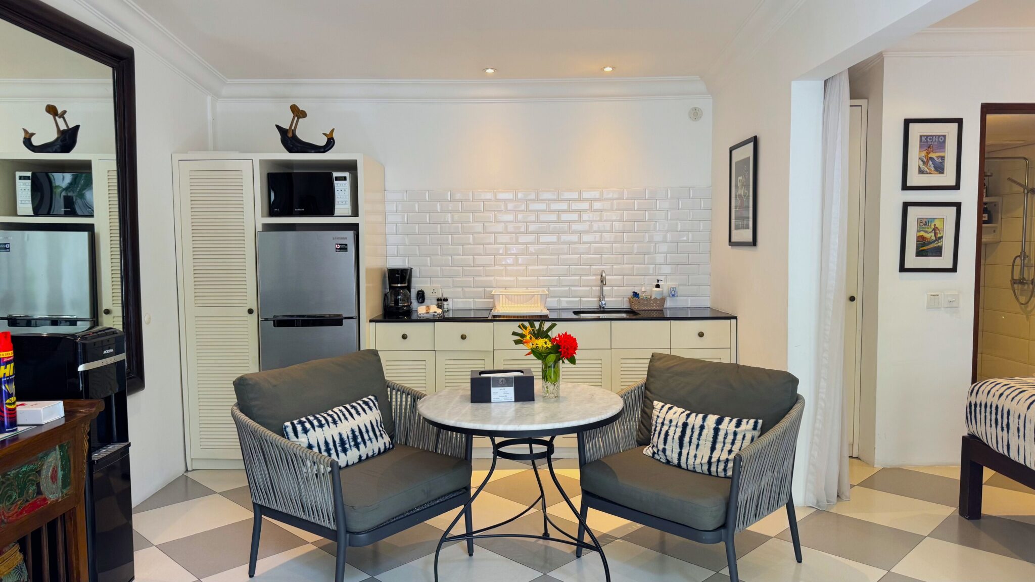 Tropical indoor-outdoor lounge space beside the open kitchen featuring elegant decor at Villa Ibu Dua Seminyak by Villa Bugis Seminyak villas.