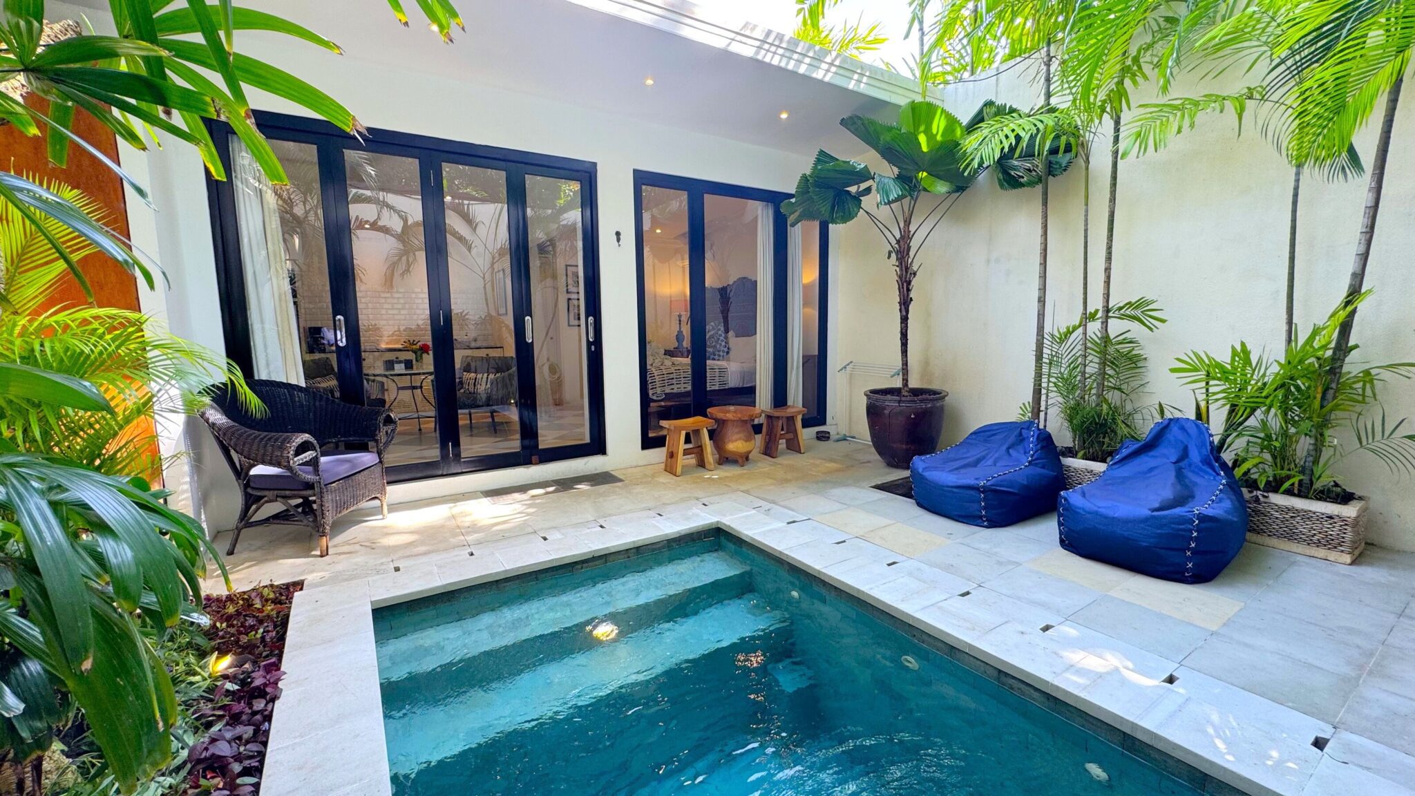 Serene poolside patio area for outdoor relaxation at Villa Ibu Dua Seminyak by Villa Bugis, ideal for couples seeking a private villa Seminyak.