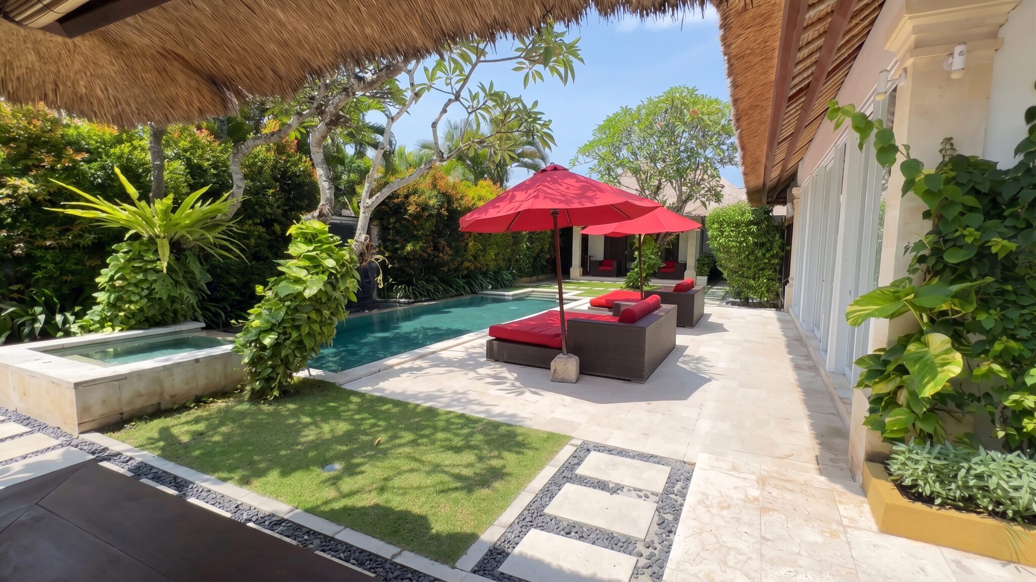 The main outdoor relaxation deck at Villa Jaclan Seminyak by Villa Bugis Seminyak villas, showcasing a crystal-clear pool surrounded by exotic greenery.