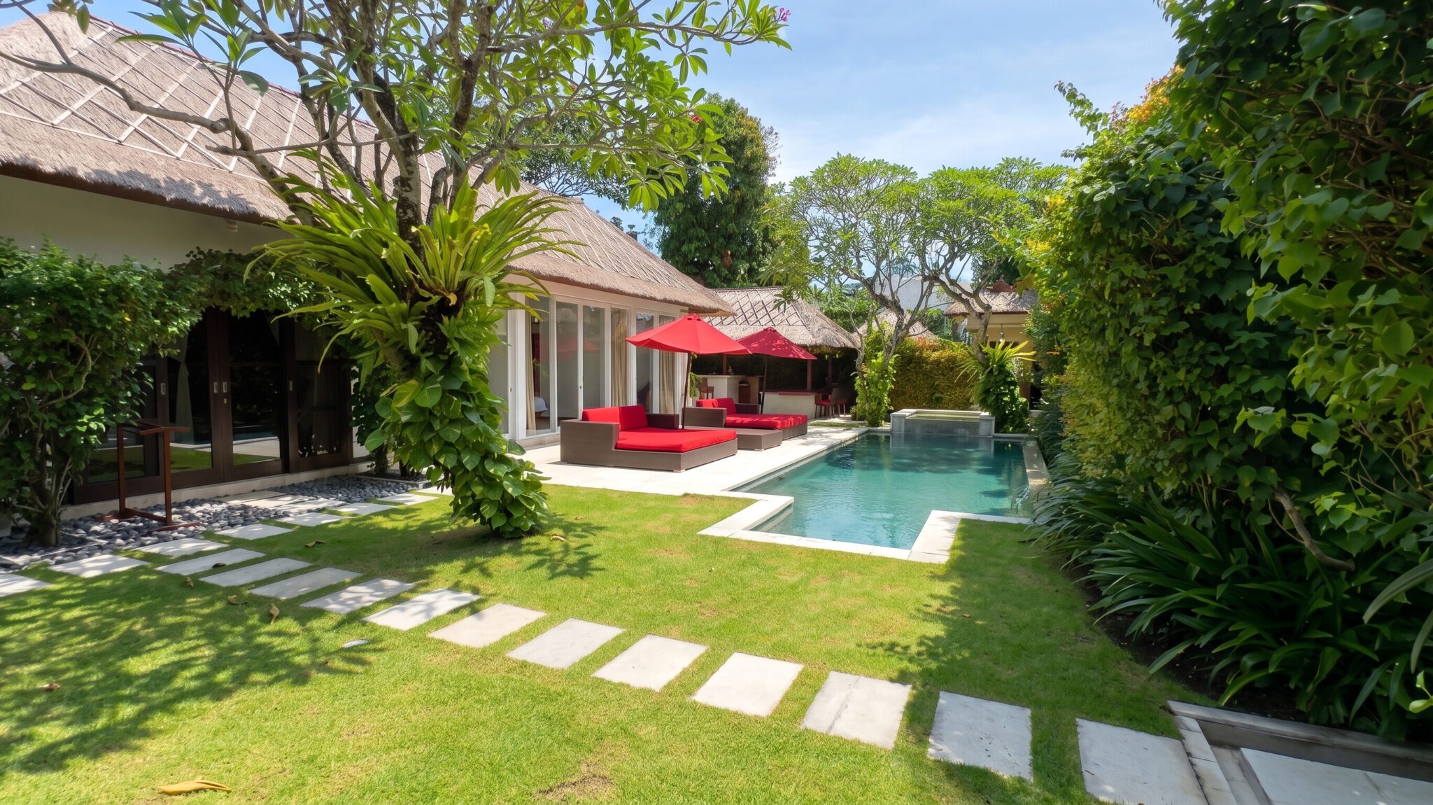 Tropical oasis landscape and spacious poolside area at Villa Jaclan Seminyak by Villa Bugis, ideal for families looking for a premium villa Seminyak.