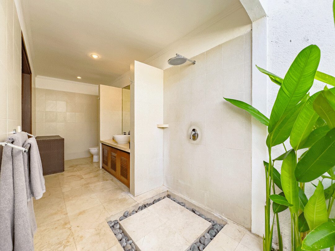 Ensuite open-air tropical bathroom for bedroom 2 at Villa Jaclan Seminyak by Villa Bugis, equipped with a modern refreshing shower in this villa Seminyak.