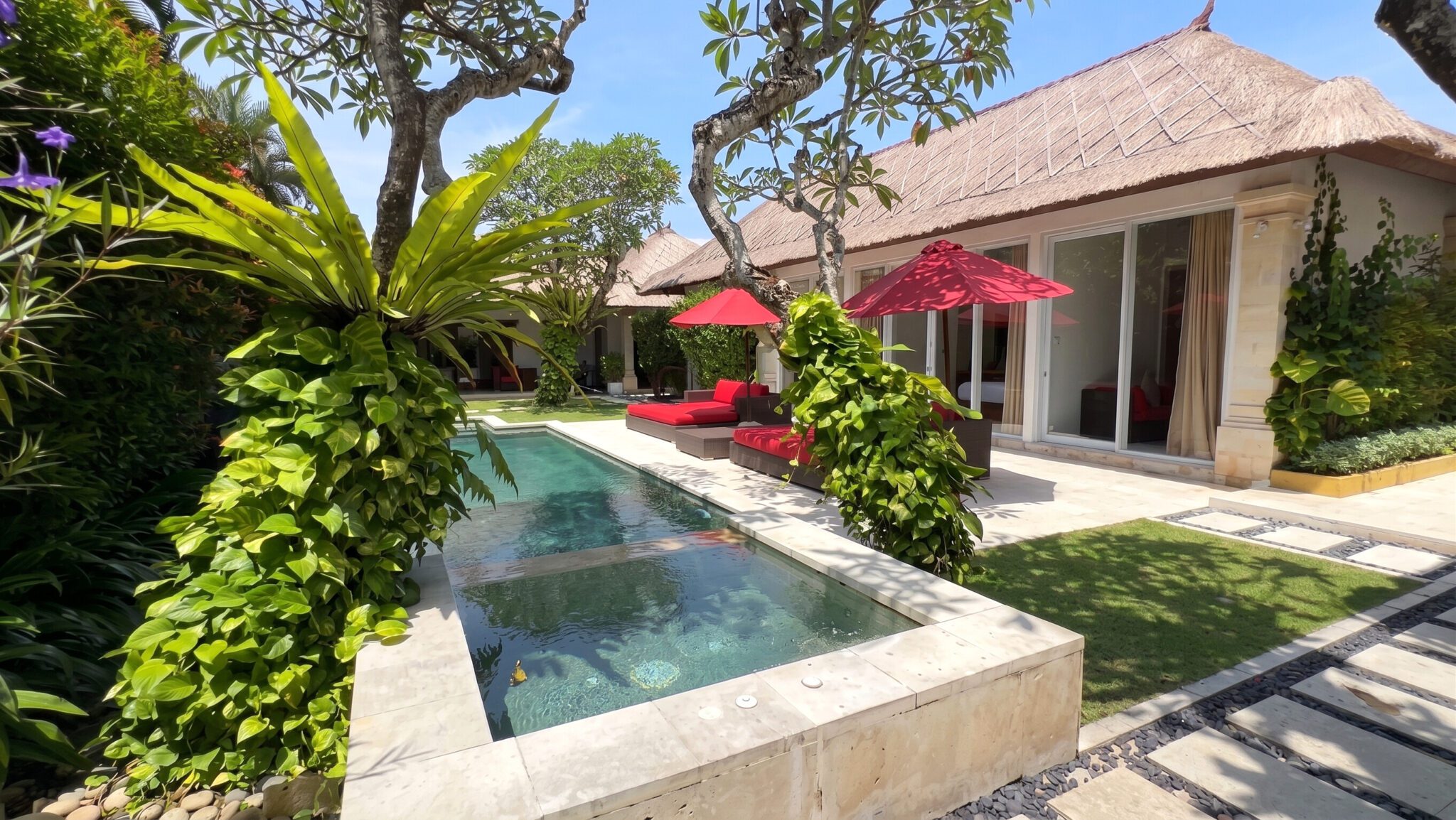 Sunny daytime view of the private pool and jacuzzi area with traditional Balinese architecture accents at Villa Jaclan Seminyak by Villa Bugis Seminyak villas.