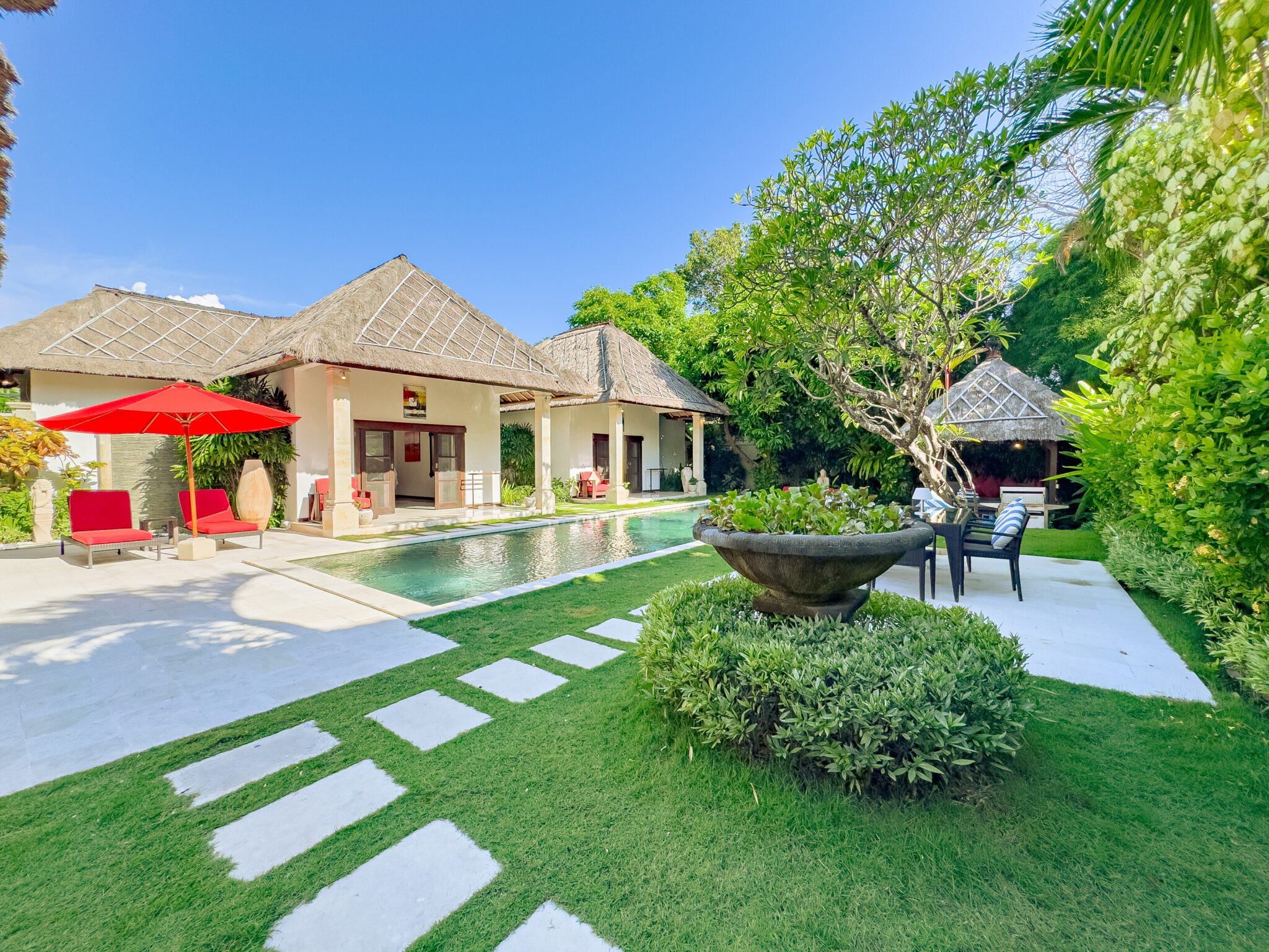 Bright outdoor sunbathing terrace surrounded by exotic greenery at Villa Kebun Seminyak by Villa Bugis villa Seminyak.