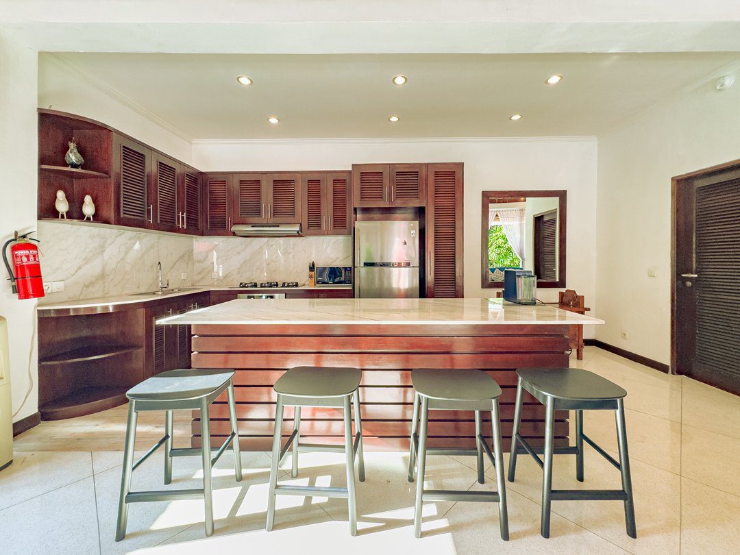 Clean fully-fitted kitchen and minimalist dining area at Villa Kebun Seminyak by Villa Bugis, offering home-style convenience in Seminyak villas.