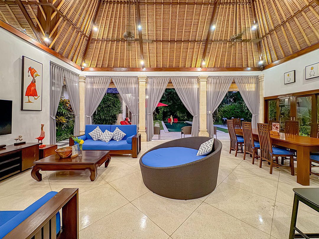 Tropical indoor-outdoor living concept with a breezy relaxation space overlooking the pool at Villa Kebun Seminyak by Villa Bugis Seminyak villas.