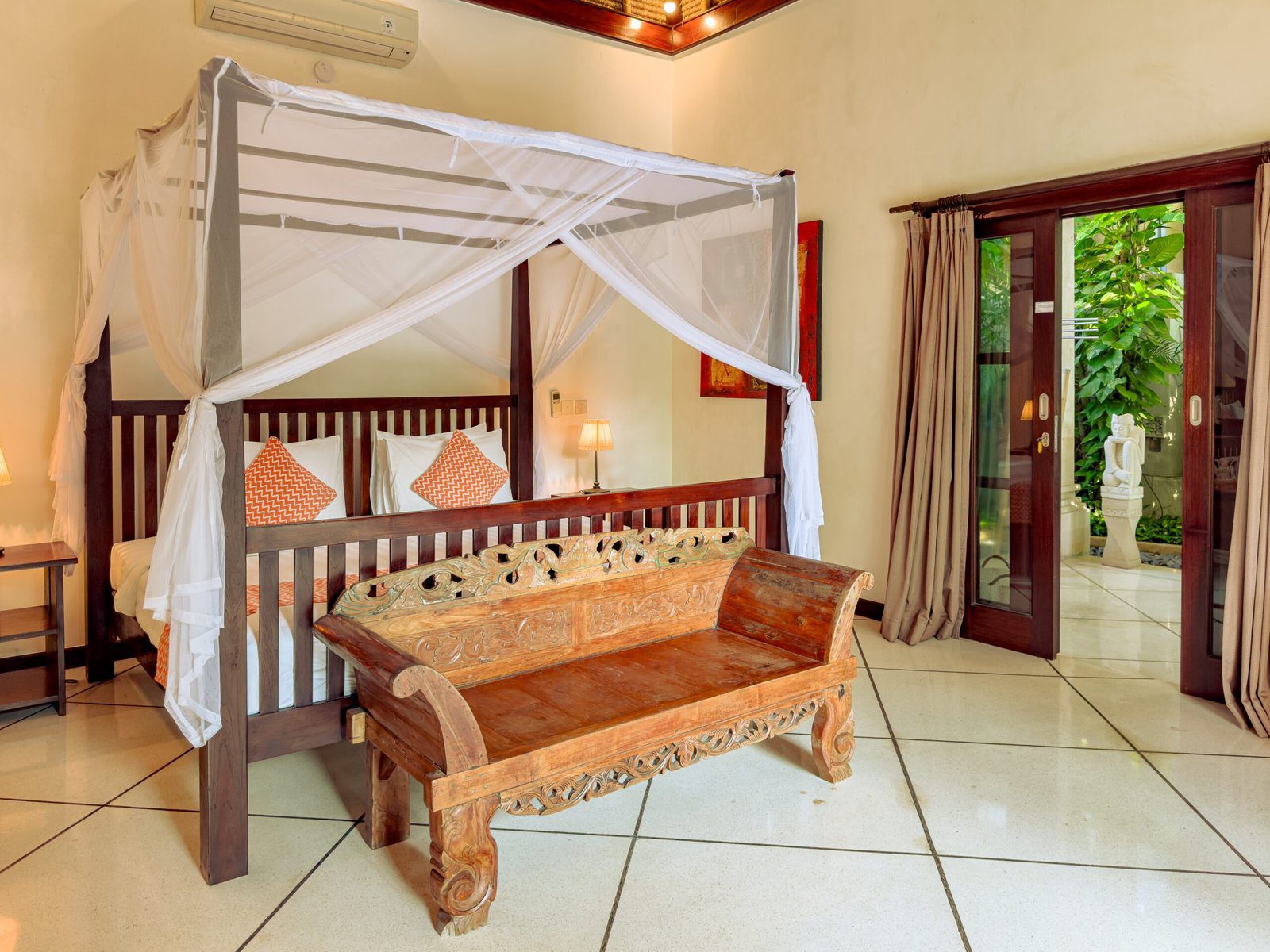 Interior layout of bedroom 1 at Villa Kebun Seminyak by Villa Bugis Seminyak villas, featuring cozy tropical decor, air conditioning, and elegant furnishings.