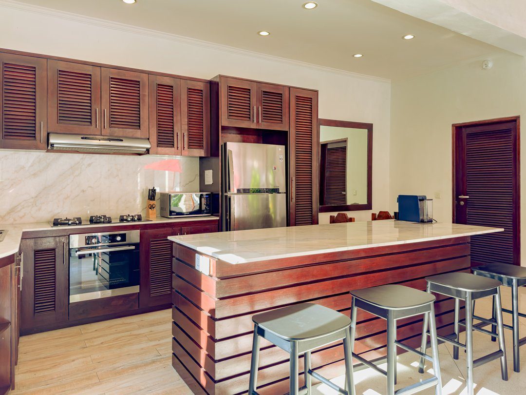 Modern open-concept kitchen fully equipped with high-quality cooking appliances at Villa Kebun Seminyak by Villa Bugis villa Seminyak.