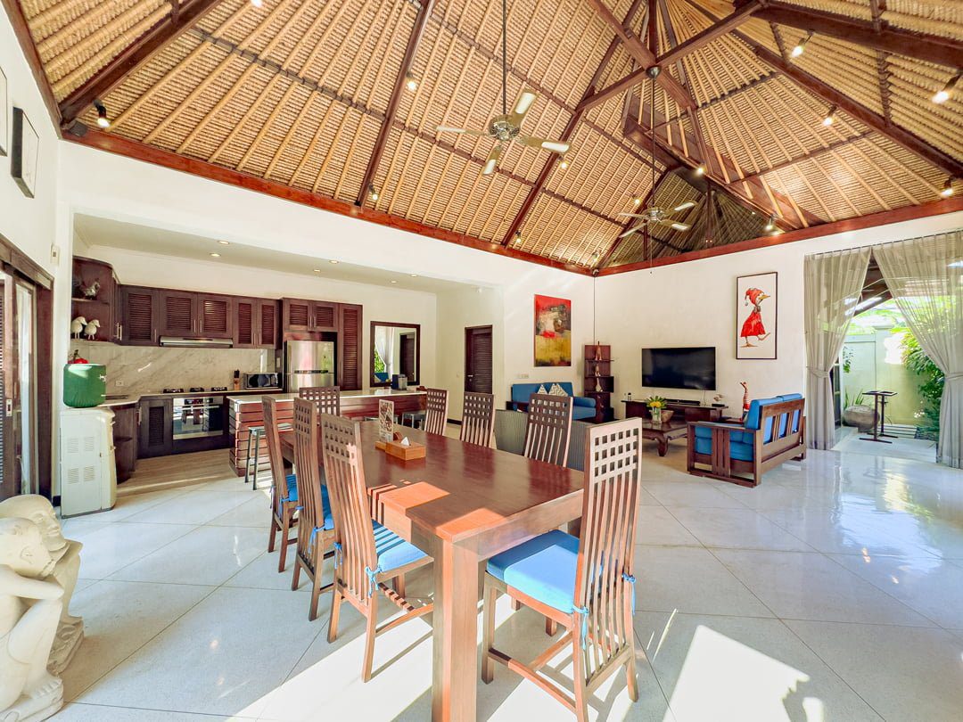 Spacious open-plan living room with comfortable plush sofas facing the private pool at Villa Kebun Seminyak by Villa Bugis villa Seminyak.