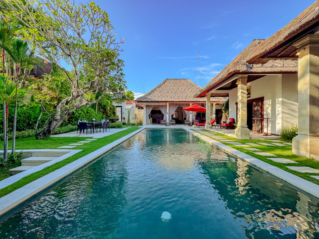 Private swimming pool surrounded by lush tropical gardens at Villa Kebun Seminyak