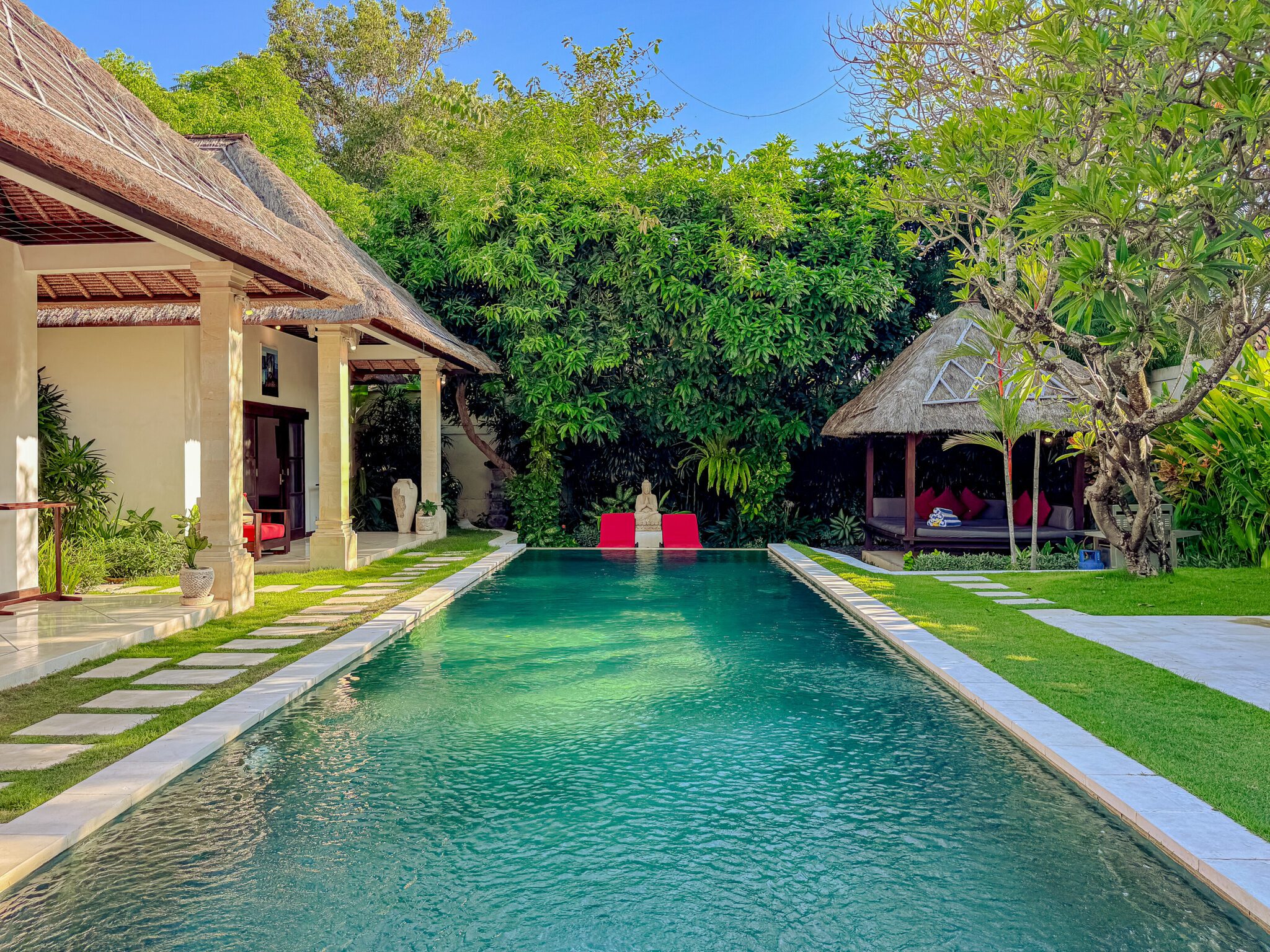 Sun-drenched private outdoor swimming pool at Villa Kebun Seminyak by Villa Bugis, a luxury villa Seminyak featuring comfortable sunbeds and a lush tropical garden.