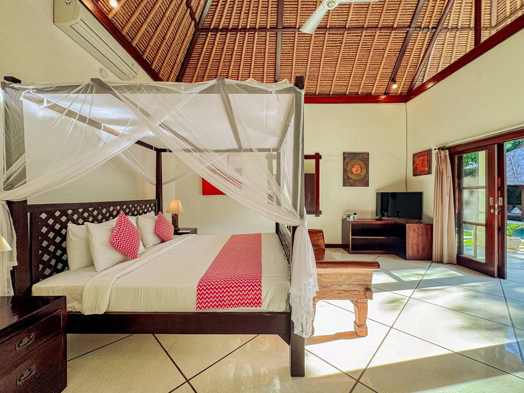 Large comfortable king-size bed with soft natural lighting in bedroom 2 at Villa Kebun Seminyak by Villa Bugis, a highly recommended Seminyak villas choice.