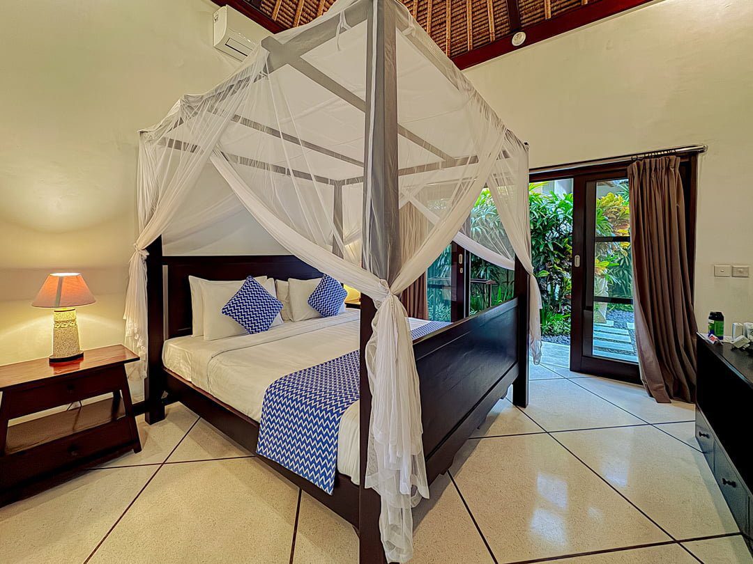 Serene third bedroom at Villa Kebun Seminyak by Villa Bugis villa Seminyak with premium bedding and a direct view overlooking the garden.
