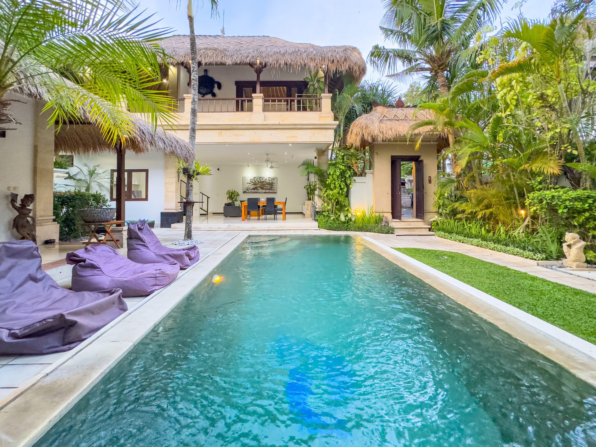Pristine private outdoor swimming pool surrounded by sun loungers and tropical plants at Villa Krisna Seminyak by Villa Bugis, a luxury villa Seminyak.