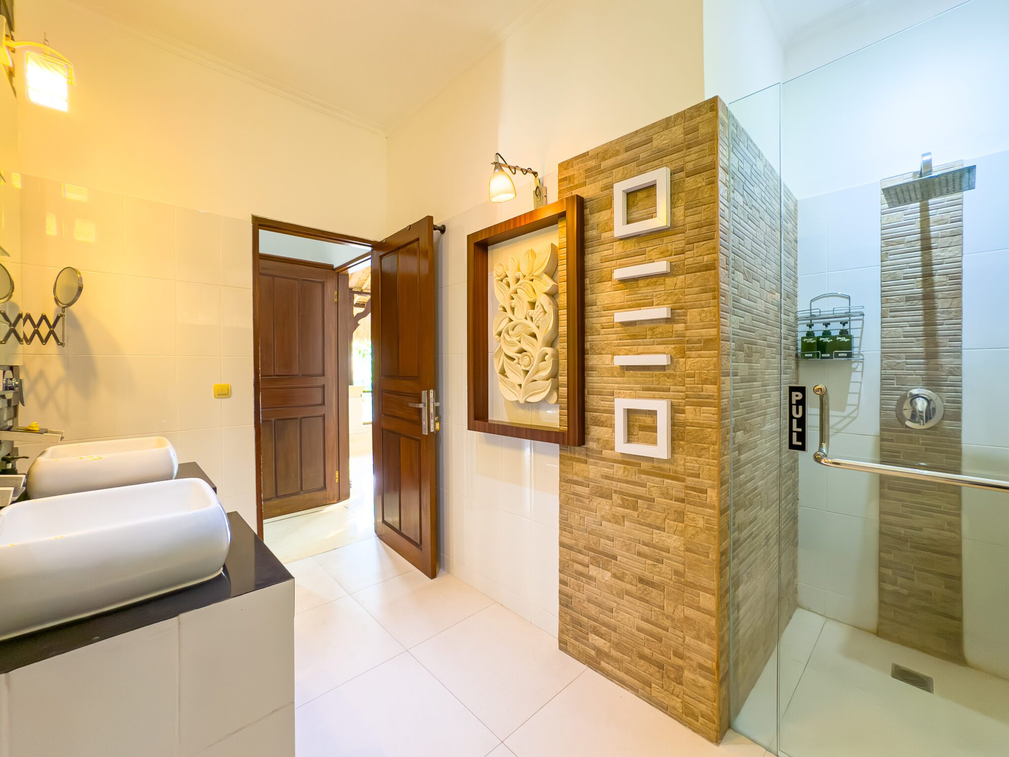 Tropical semi-outdoor ensuite bathroom attached to bedroom 1 at Villa Krisna Seminyak by Villa Bugis, offering a unique villa Seminyak experience.