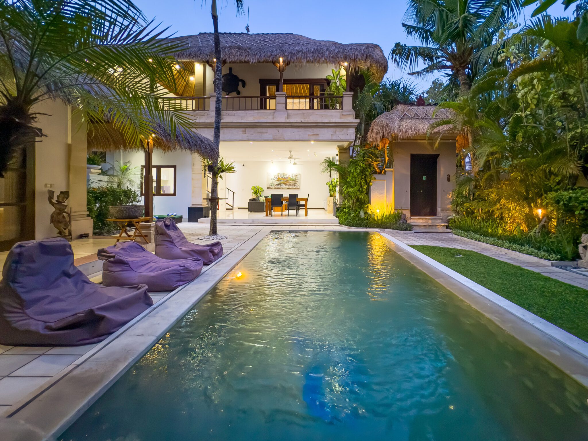 Serene evening ambiance with warm pool lighting reflecting on the water at Villa Krisna Seminyak by Villa Bugis villa Seminyak.