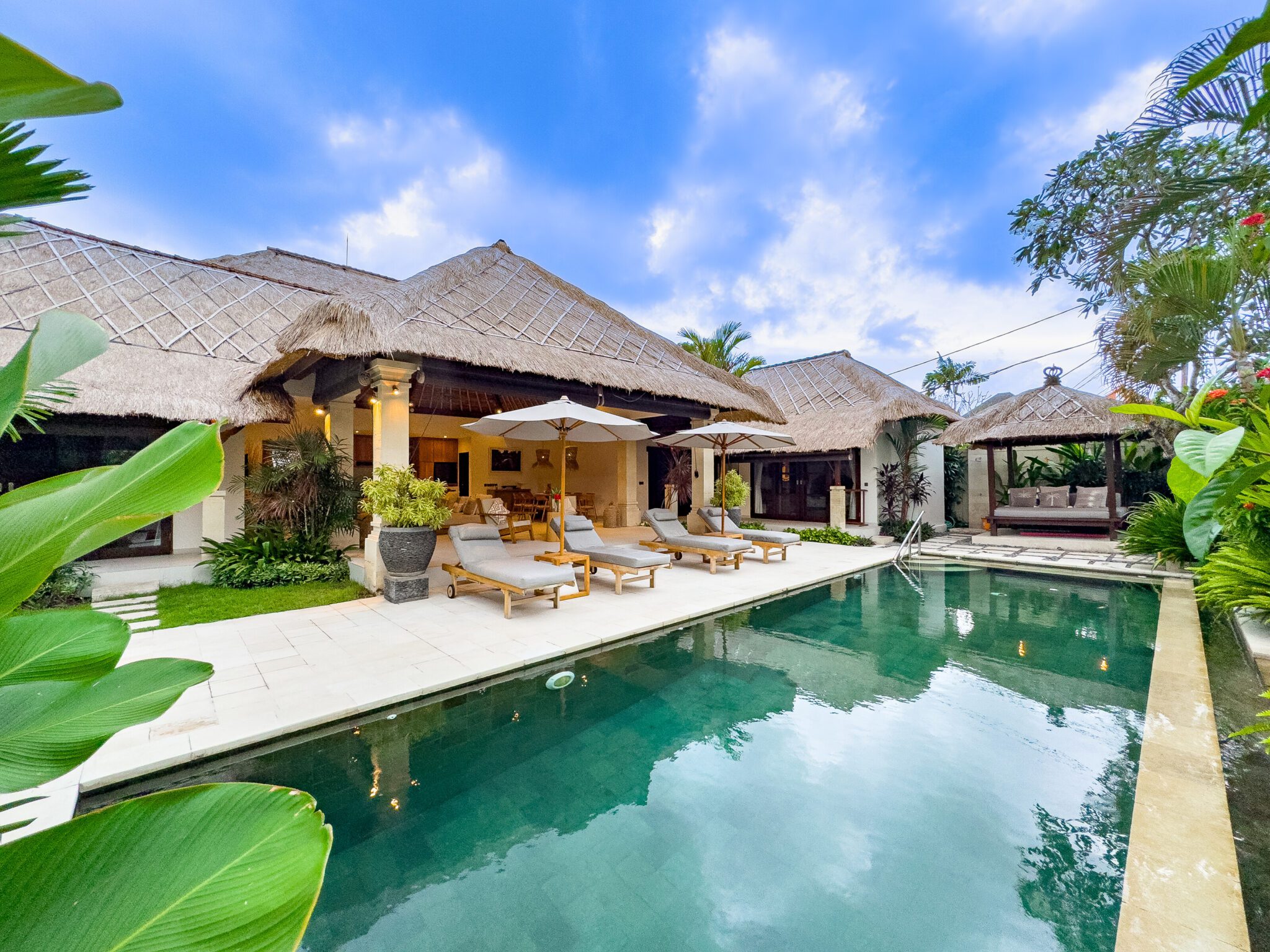 Tropical oasis landscape and poolside relaxation area at Villa Olive Seminyak by Villa Bugis, ideal for family vacations in a villa Seminyak.