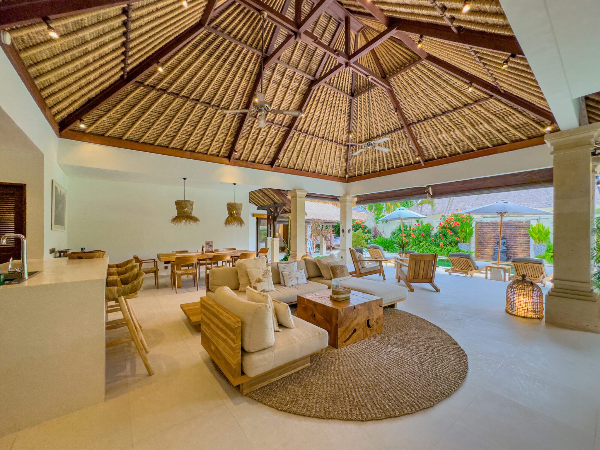 Open-air living room pavilion with plush sofa seating facing the private pool at Villa Olive Seminyak by Villa Bugis villa Seminyak.