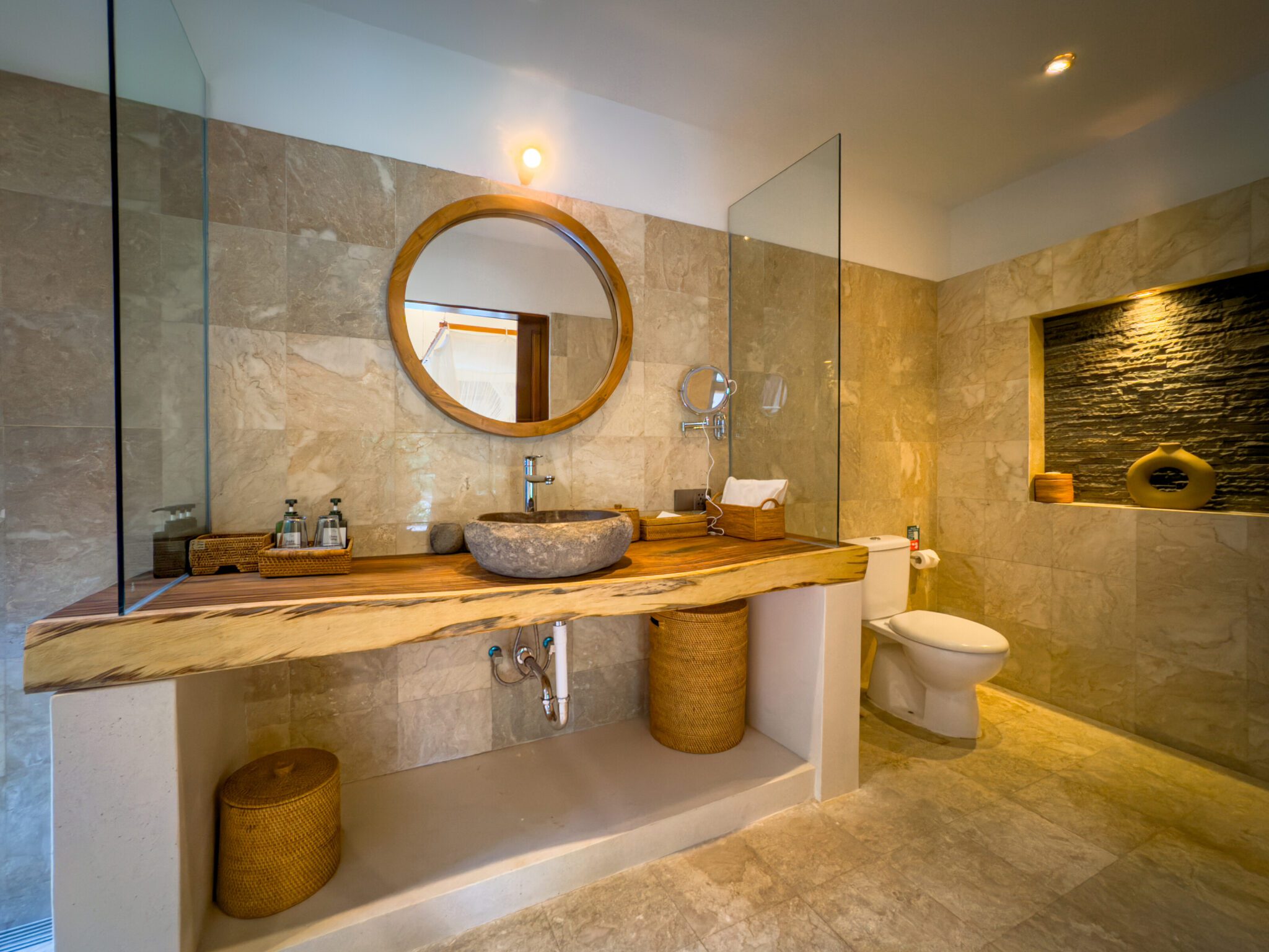 Clean modern vanity, stone basin, and refreshing shower area in the master bathroom at Villa Olive Seminyak by Villa Bugis Seminyak villas.