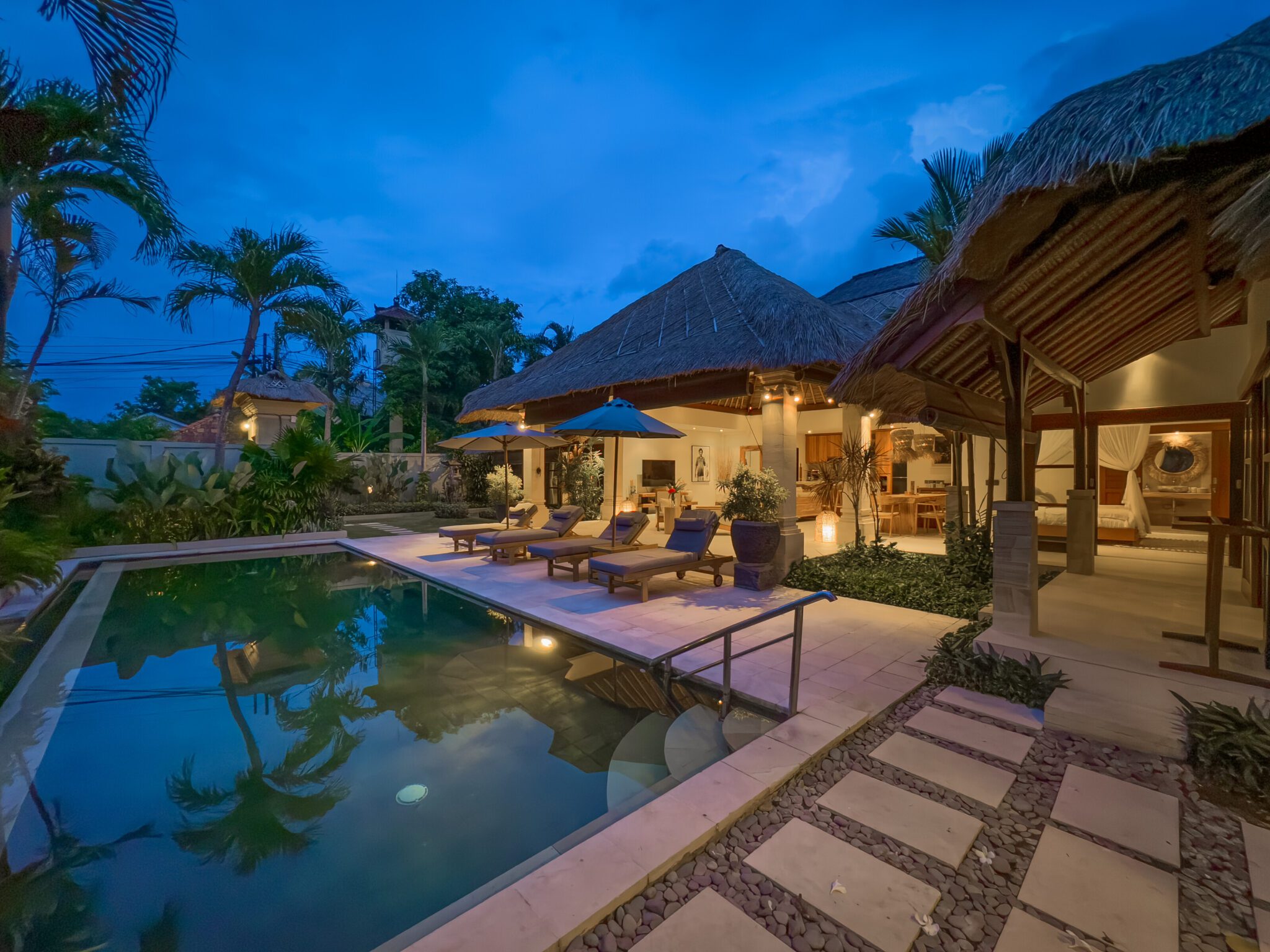 Serene evening ambiance with pool lights reflecting on the water at Villa Olive Seminyak by Villa Bugis villa Seminyak.