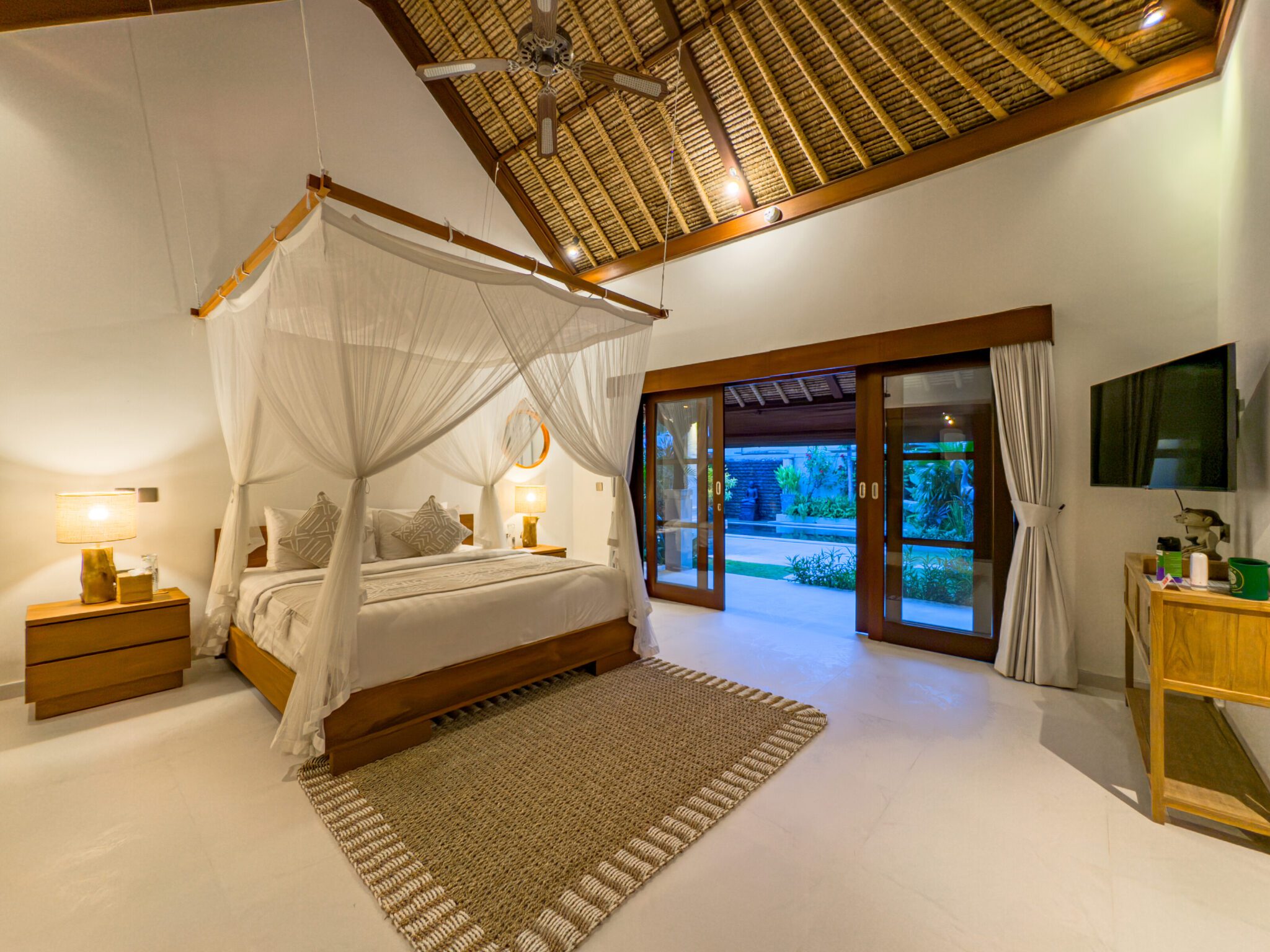Spacious interior layout of bedroom 1 at Villa Olive Seminyak by Villa Bugis Seminyak villas, complete with air conditioning and elegant wooden furnishings.